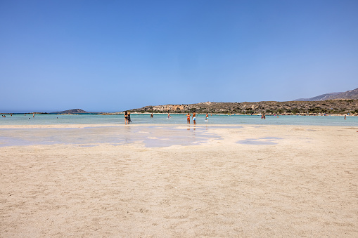 Elafonisi, Crete, Greece - Sept 19, 2021: People relaxing on the famous pink coral beach of Elafonisi on Crete, Mediterannean sea, Greece