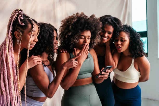 istock Excited woman using cellphone with friends. 1498885599