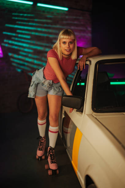 istock Stylish girl on roller skates with car. 1498887218