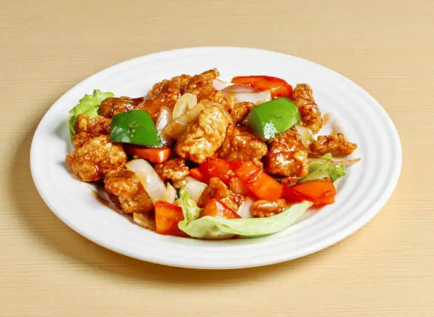 sweet and sour pork served in dish isolated on background top view singapore food