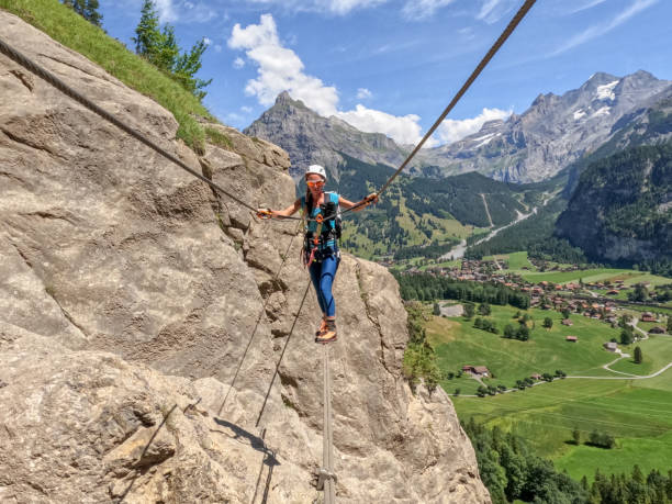 istock Woman on Via Ferrata crossing a monkey bridge, suspension bridge 1498894689