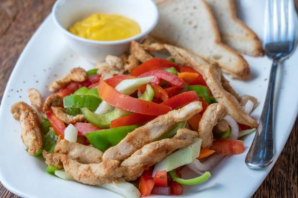 istock Roasted chicken fillet with vegetables and bread on a white plate, closeup 1498897731