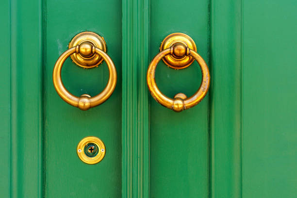 abstract detail of a brass knocker handle and green door