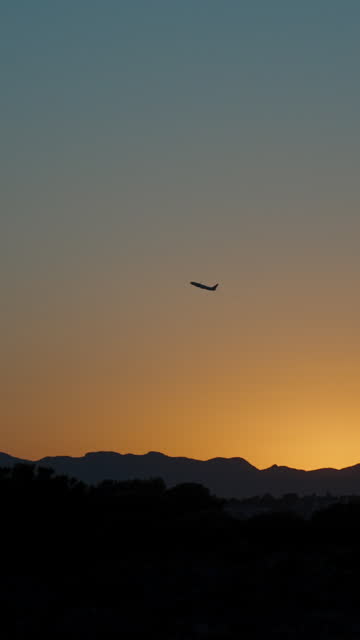 The plane takes off at sunset. Orange sky, sun behind the mountain Vertical, Social Media