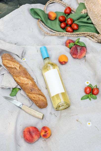istock Bottle of white wine and fresh fruit on a picnic blanket. 1498898636