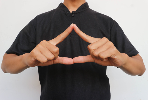 The man with the black shirt raised his hand to show triangle shape.