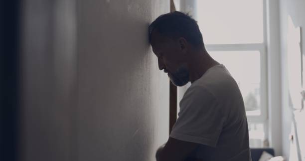 istock Depressed man in the hall. Resting forehead against wall 1498902213