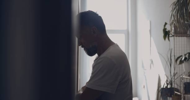 istock Depressed man in the hall. Resting forehead against wall for support 1498902219
