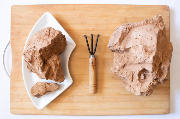 Edible brown clay stones on a cutting board on a white background