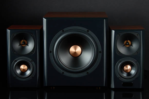 istock Sound audio system with two satellites and subwoofer on dark background. 1498905642