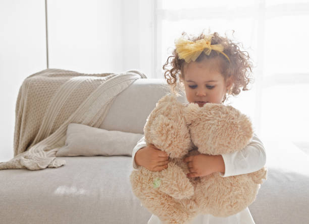 Cute little girl playing with teddy bears in the living room