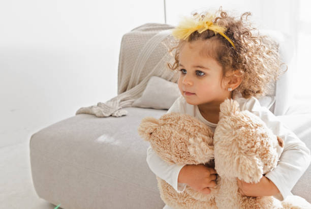 Cute little girl playing with teddy bears in the living room