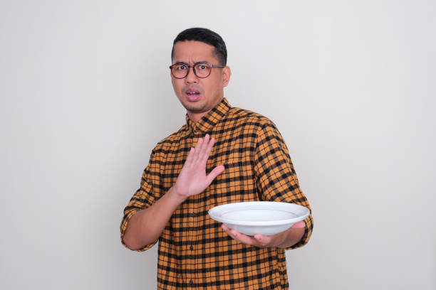 istock A man showing stop hand sign with worried expression while holding empty dinner plate 1498906406