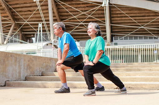 Asian elderly couple exercising outdoors together. Sports concept. health care in retirement