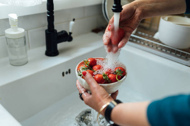 부엌 싱크대에서 딸기를 씻는 여자의 손 - washing fruit preparing food strawberry 뉴스 사진 이미지