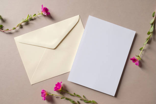istock White blank greeting or invitation card and envelope with pink flower decoration. Mock up presentation.. 1498923992