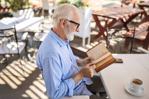 istock Senior man reading book and smiling 1498924284