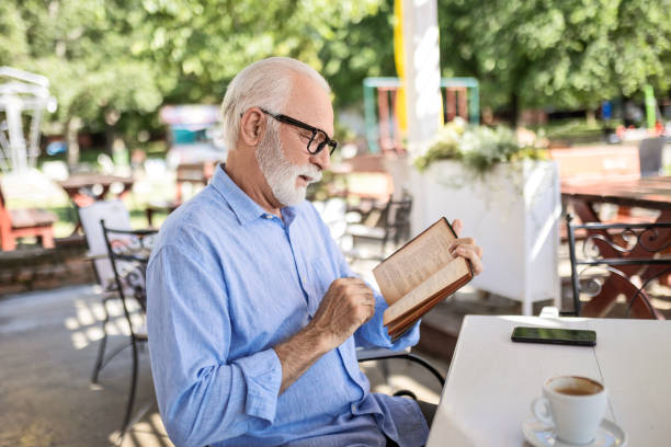 istock Senior man reading book and smiling 1498924291