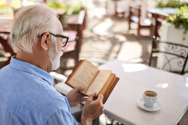 istock Senior man reading book and smiling 1498924300