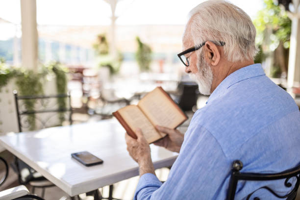 istock Senior man reading book and smiling 1498924309