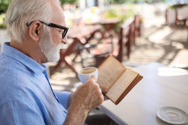 istock Senior man reading book and smiling 1498924329