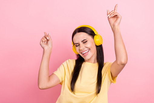 Photo of cute sweet lady wear yellow t-shirt earphones dancing having fun isolated pink color background.