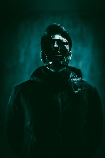 Scary man wearing a mask and standing under neon lights.