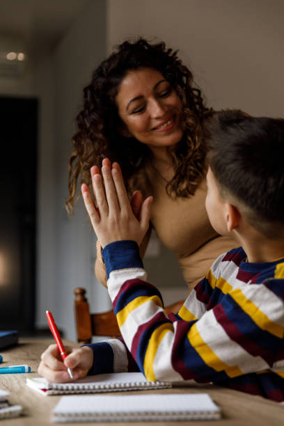istock Mother and son high-fiving each other while doing homework and studying together 1498927946