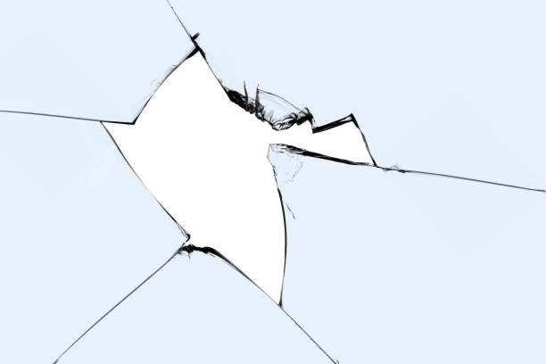istock A broken window with cracks and pieces of sharp glass. Cracked texture for design. 1498928657
