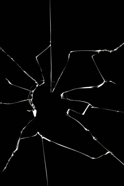 istock Black broken glass and white cracked texture on window broken by vandals. Texture for design. 1498928684
