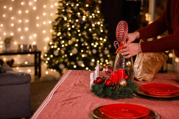 istock Young man creating a rustic center piece on a dining table for Christmas dinner 1498930720