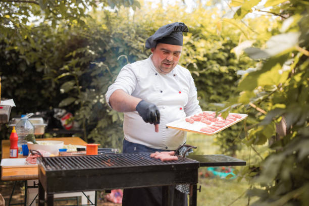 istock Chef wearing black gloves and working with meat on grill 1498932544