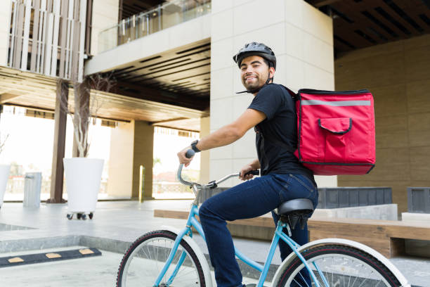 istock Rear view of a delivery worker with a backpack riding a bike 1498933186