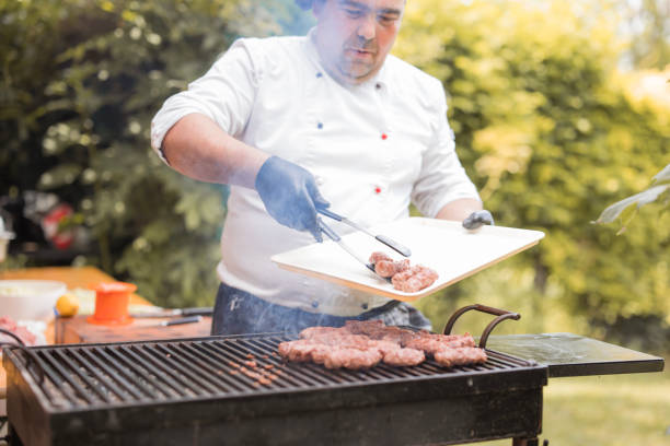 istock Chef preparing a grill, handling meat with chef's tweezers 1498933217