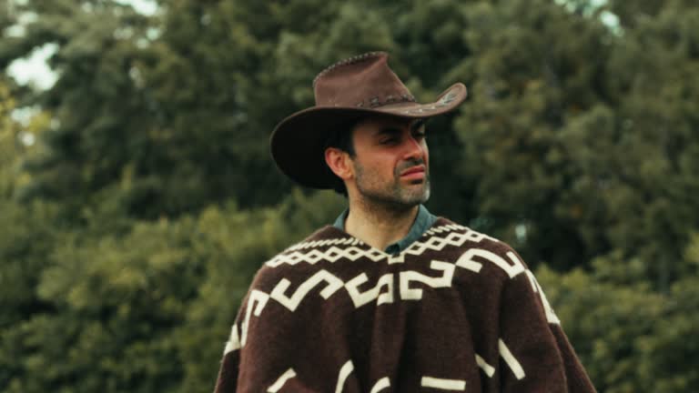 Man horseback to a horse in a ranch with cowboy dresses