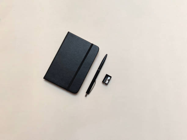 검은색 노트북, 검은색 펜, 검은색 깎기. 흰색 바탕에 - spiral notebook audio 뉴스 사진 이미지