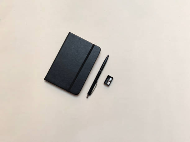 istock black notebook, black pen and black sharpener. On a white background 1498934170