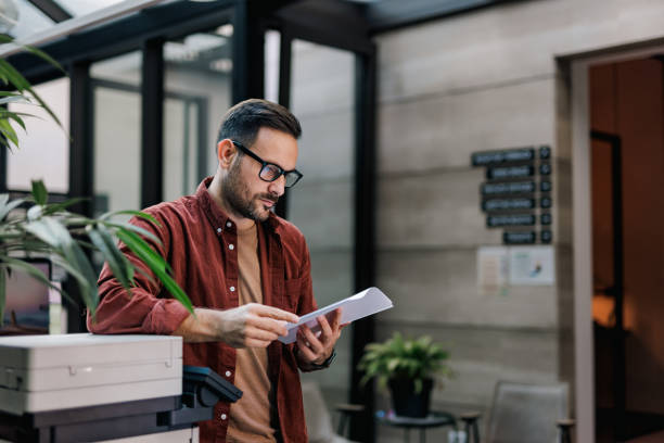 istock Side profile of a serious-looking businessman, holding and reading some documents. 1498934256