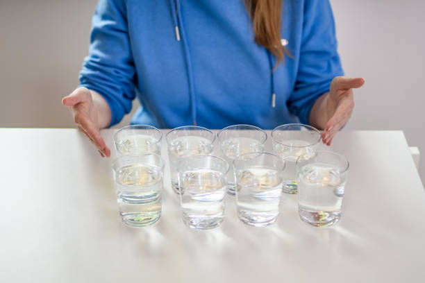 восемь стаканов с минеральной водой, стоящей на столе - water glass glasses number 8 стоковые фото и изображения