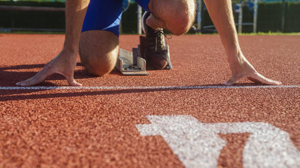 istock Male hands on the run starting line, ready, set and go 1498937330