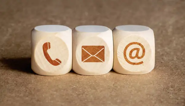 Contact us concept. Wooden blocks with email, mail and telephone icons.