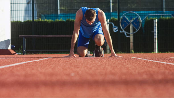 istock Male sprinter, hands on the line and legs on starting block, front view 1498937467