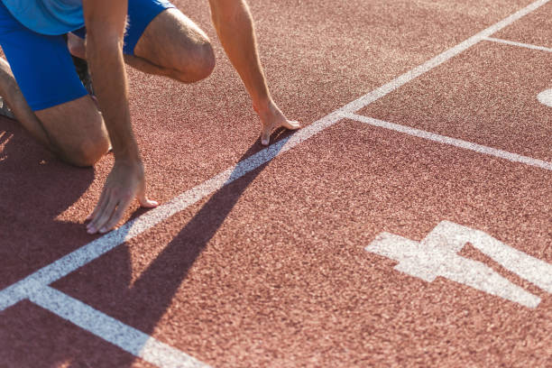 istock Male hands on the run starting line, ready, set and go 1498937729