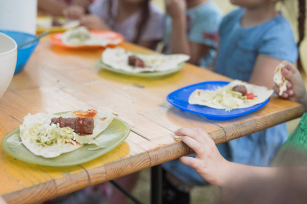 Group of people eating barbecue outdoors during a picnic