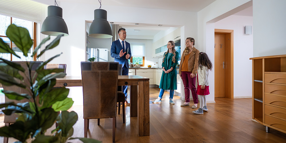 Real estate agent showing lesbian couple with daughter modern apartment