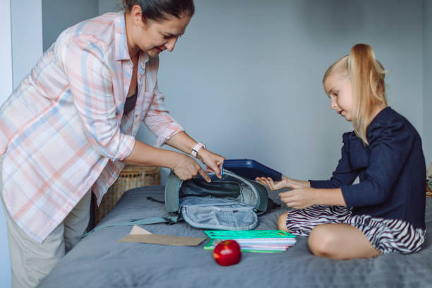 istock Mother helping her daughter packing things for school 1498948982