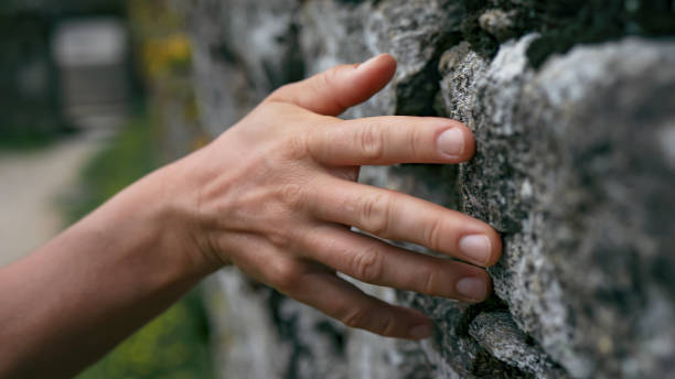 istock The tranquility of touch: Woman's hand gracefully gliding across a textured rock surface 1498950281