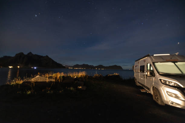 istock A camper van illuminated parked by the sea, starry night without moon at night. 1498950899