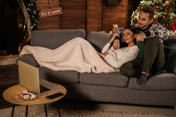 istock Romantic young couple cuddling and watching TV on a cozy winter's evening 1498952271