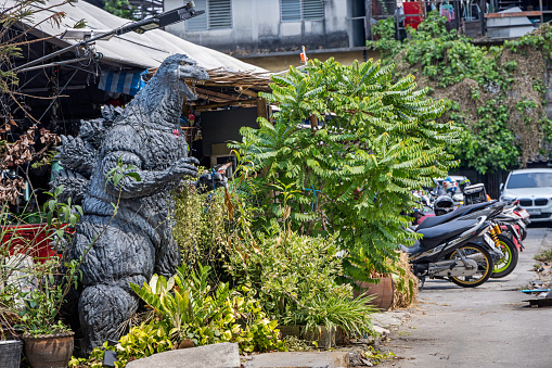 Bangkok, Thailand - March 24th 2023: Figure of a dinosaur outside a night club in a side street in the center of the Thai capital